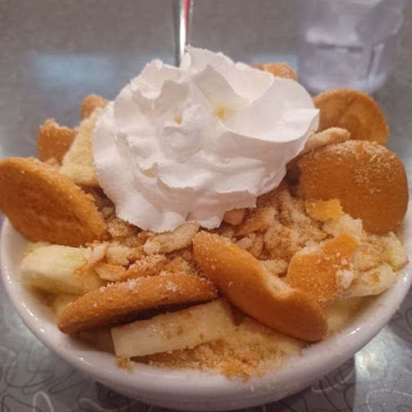 A close-up of RedEye Diner's banana pudding with vanilla wafers, banana slices, and whipped cream.